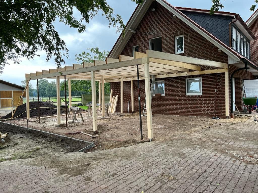 Ein neu gebautes Carport mit einem Haus.