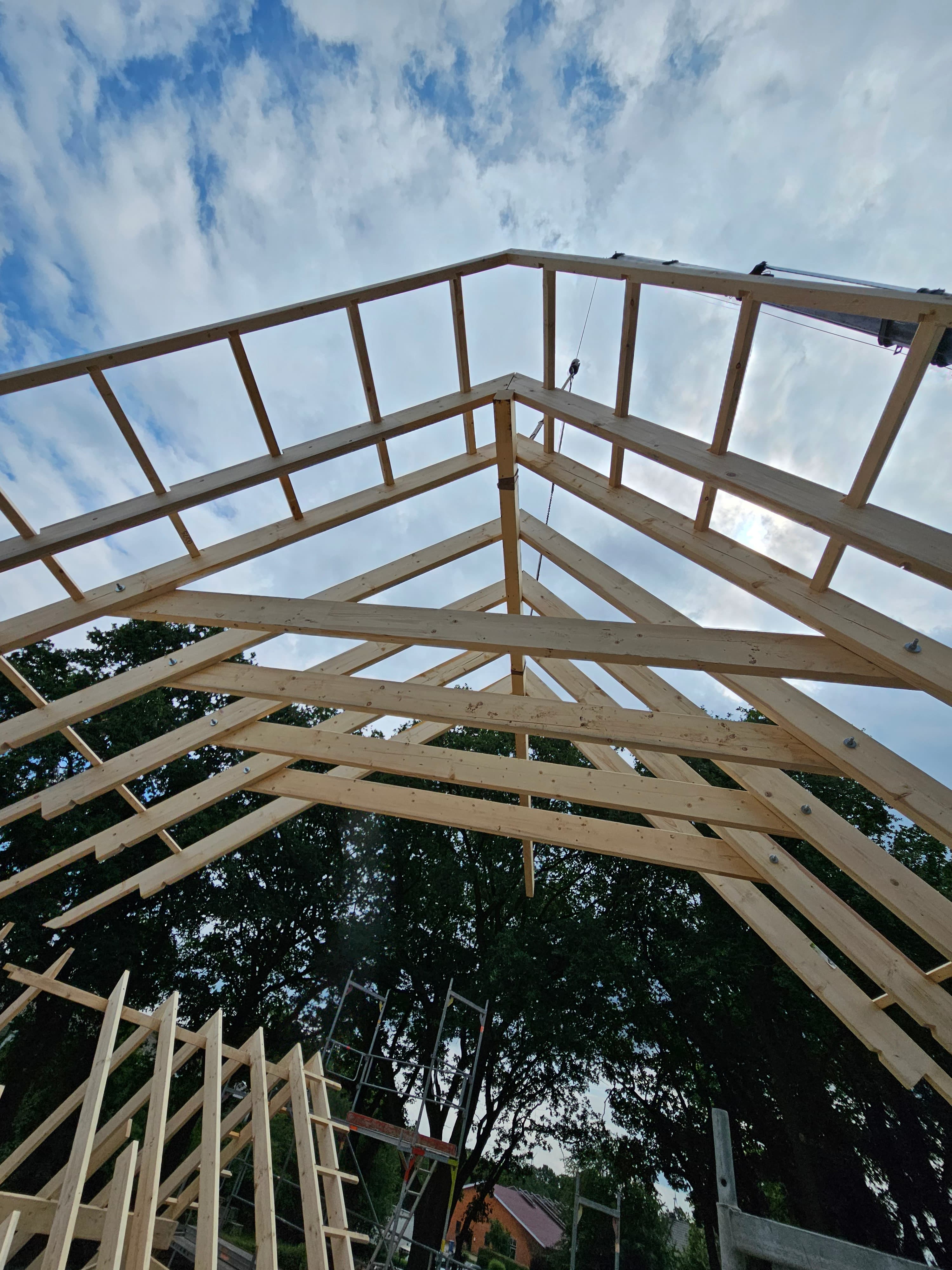 Ein schwebender Dachstuhl, der von einem Krahn herabgelassen wird.