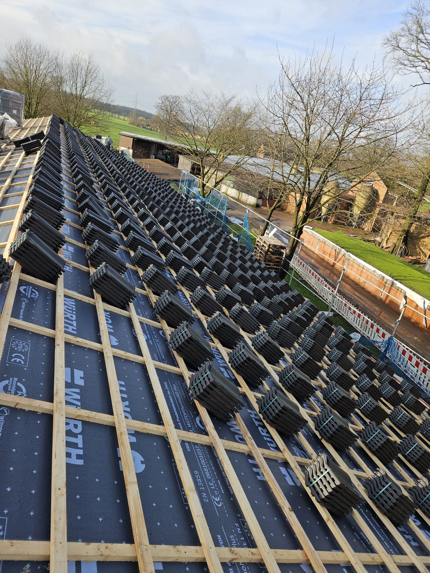 Ein Dach mit Ziegelsteinen, welche noch nicht verlegt wurden.